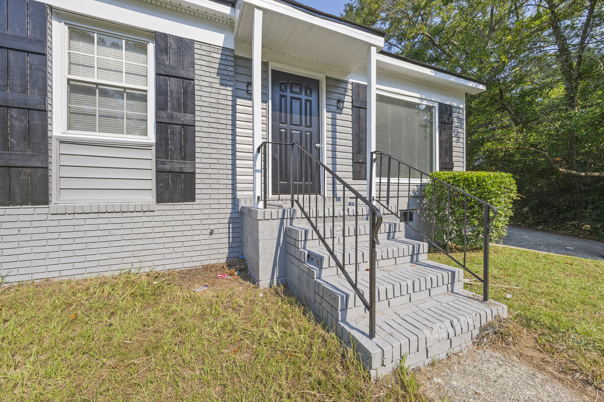 Front of 3542 Windsor Circle — light grey brick and siding, black front door, brick steps with black railings